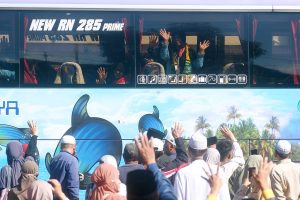 Sejumlah jamaah calon haji melambaikan tangan dari dalam bus saat diberangkatkan menuju Asrama Haji Sukolilo, Surabaya, Jawa Timur, dari Terminal Ubung, Denpasar, Bali, Jumat (8/5/2026).