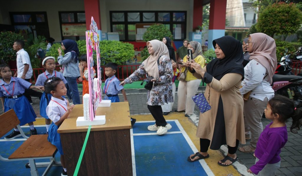 Orang tua mengabadikan gambar anaknya pada frame yang disediakan sekolah saat mengikuti Masa Pengenalan Lingkungan Sekolah (MPLS) hari pertama tahun ajaran 2026/2027  di SD Negeri 06 Pagi Petukangan Utara, Jakarta Selatan, Senin (13/7/2026). Sebanyak 64 peserta didik baru mengikuti MPLS selama lima hari untuk mengenal lingkungan sekolah, berinteraksi dengan guru dan tenaga kependidikan, serta memahami metode pembelajaran dan tata tertib yang berlaku. MI/RAMDANI