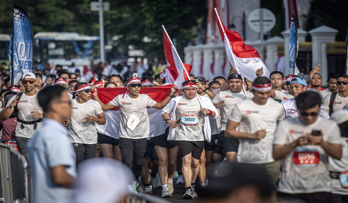 Sekretaris Kabinet Teddy Indra Wijaya (tengah) bersama peserta lainnya berlari saat mengikuti Merdeka Run 8.0 K 2025 di depan Istana Merdeka, Jakarta, Minggu (24/8/2025).