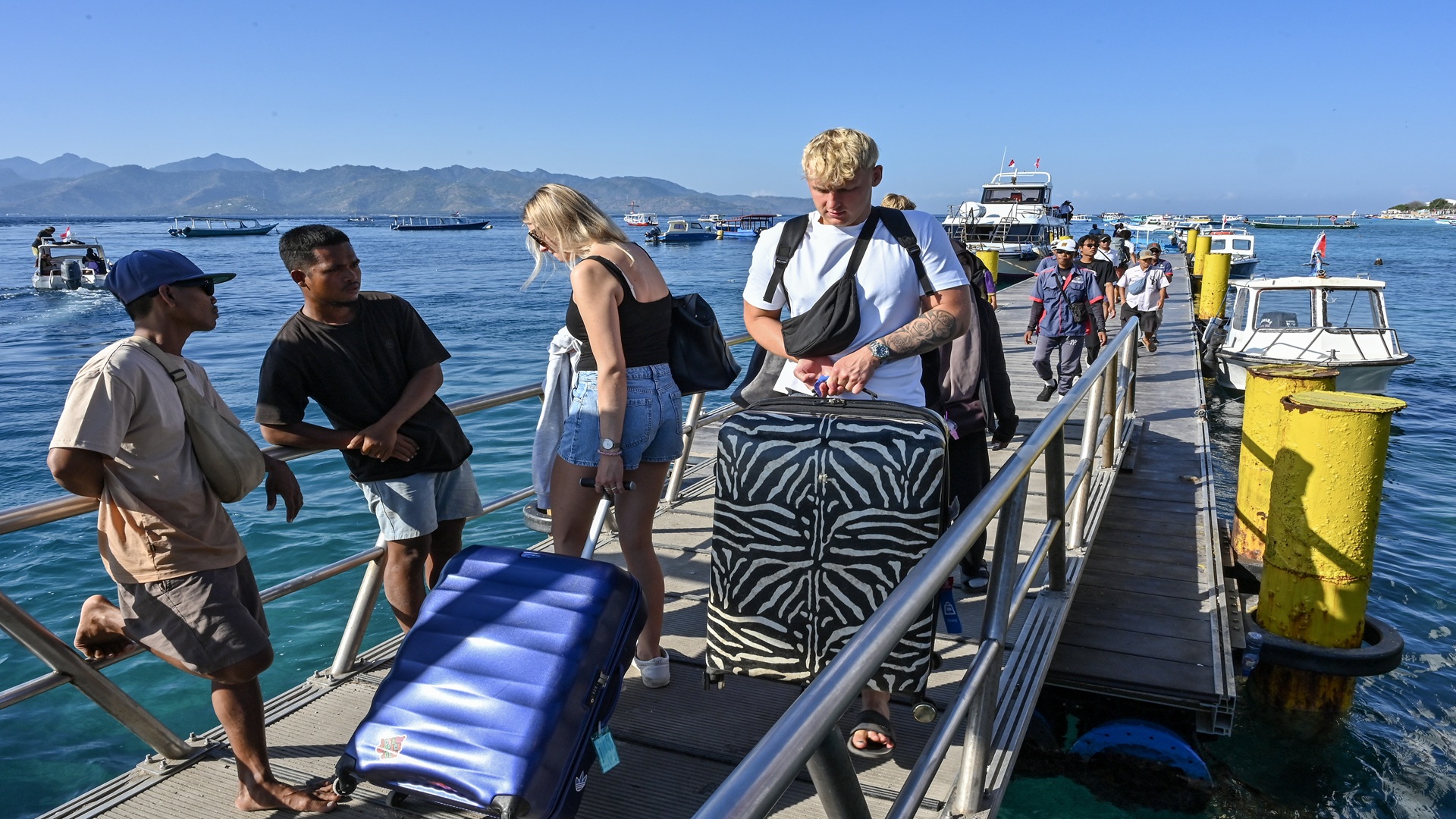 Sejumlah wisatawan asing membawa kopernya saat tiba di pelabuhan Gili Trawangan, Desa Gili Indah, Kecamatan Pemenang, Tanjung, Lombok Utara, NTB, Senin (10/8/2026).