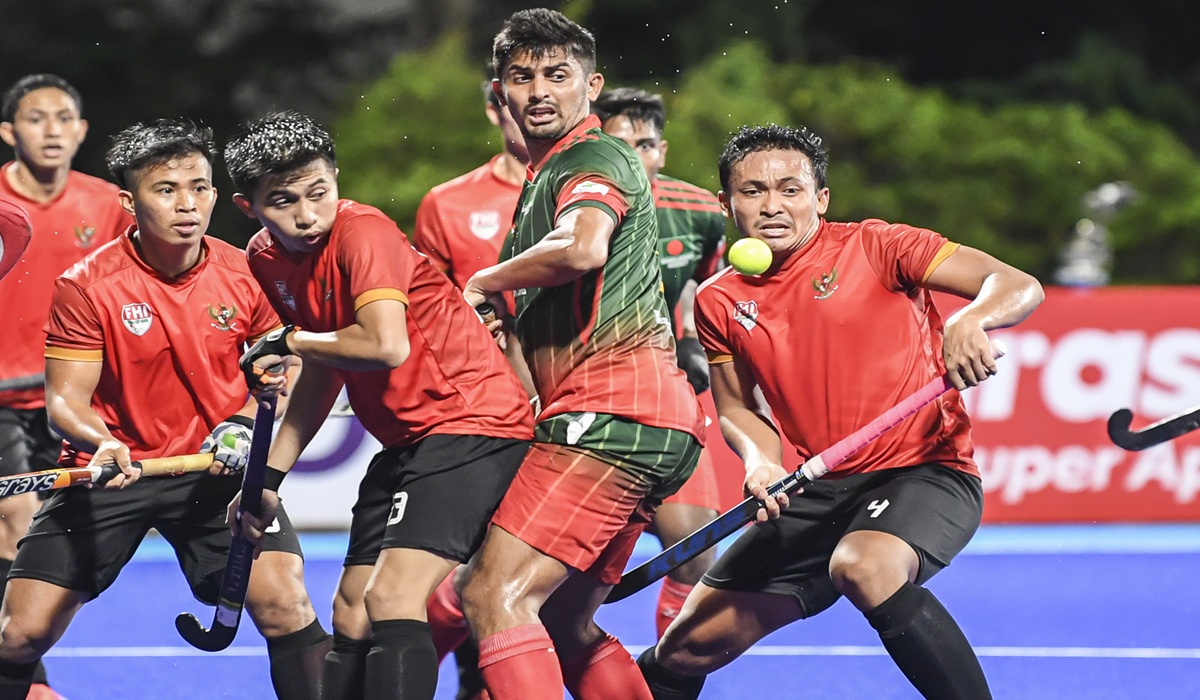 Pemain hoki putra Indonesia Asrul Alam (kanan) berusaha menghalau bola dari pemain hoki putra Bangladesh Milon Hossain (tengah) dalam penyisihan grup B Piala Asia Hoki Putra 2022 di Lapangan Hoki, Komplek Gelora Bung Karno, Senayan, Jakarta, Jumat (11/3/20